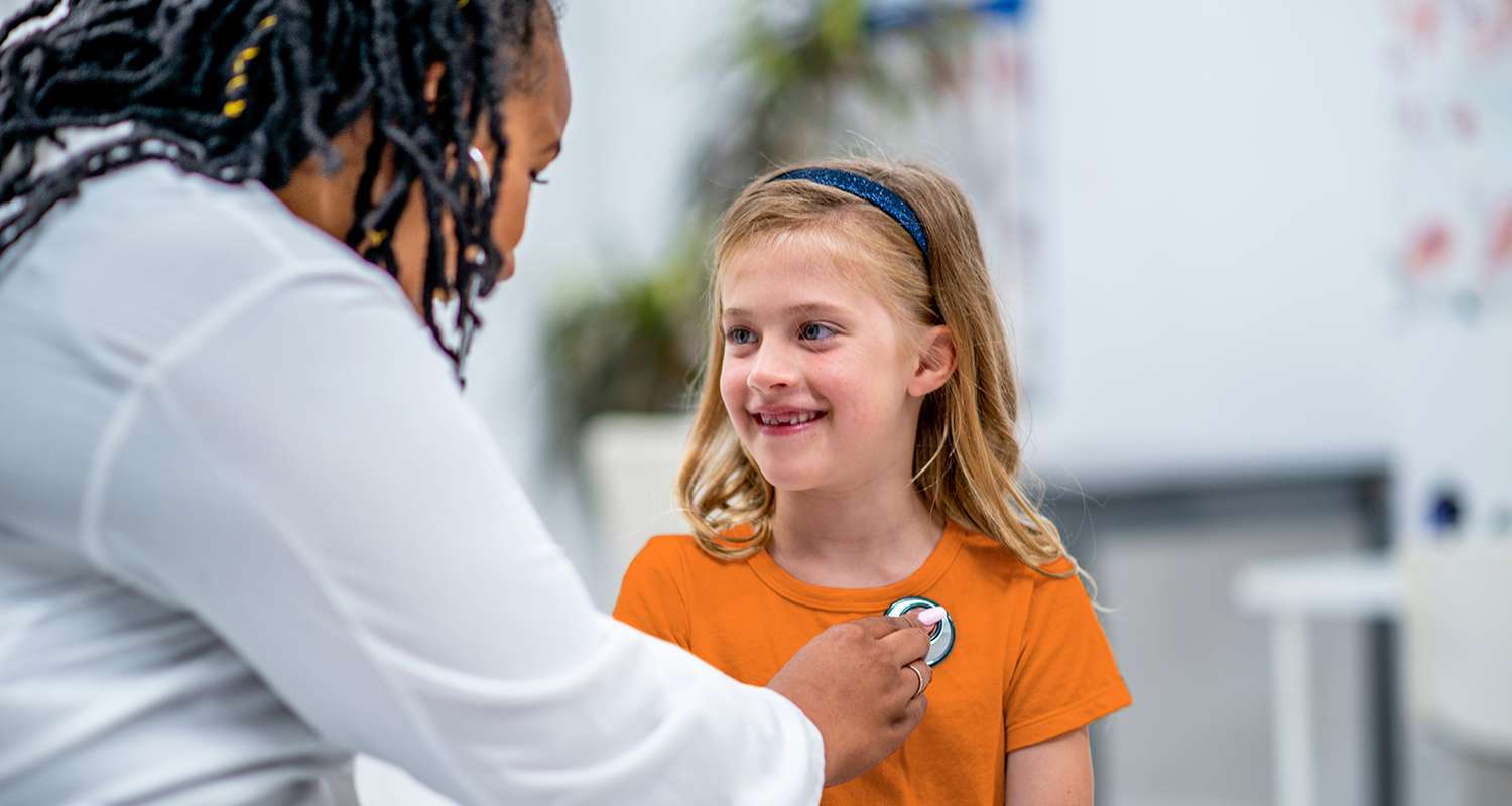 School-nurse-checking-a-student-with-a-stethescope