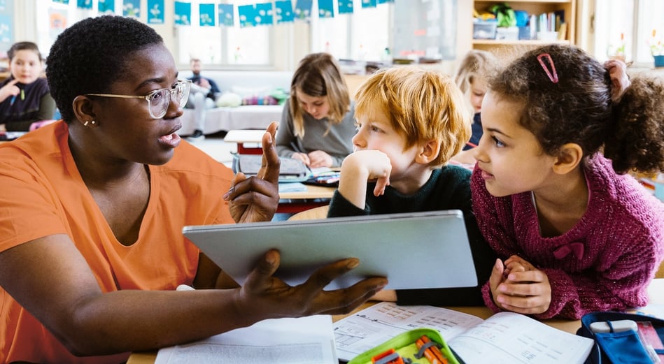 teacher talking to two elementary students